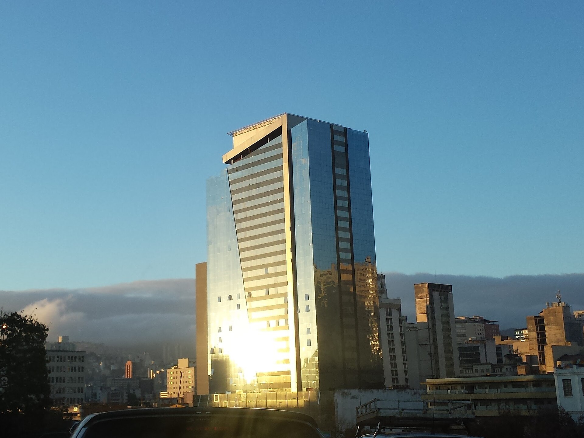 Edifício corporativo de vidro em Belo Horizonte refletindo a luz dourada do entardecer
